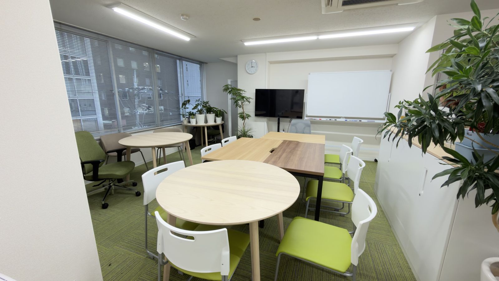 401B号室 MEETING ROOMの室内。明るい部屋に丸テーブルとモニター、ホワイトボード